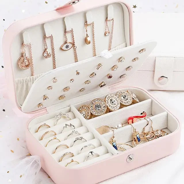 Boite a bijoux rose avec pleins de bijoux ranger