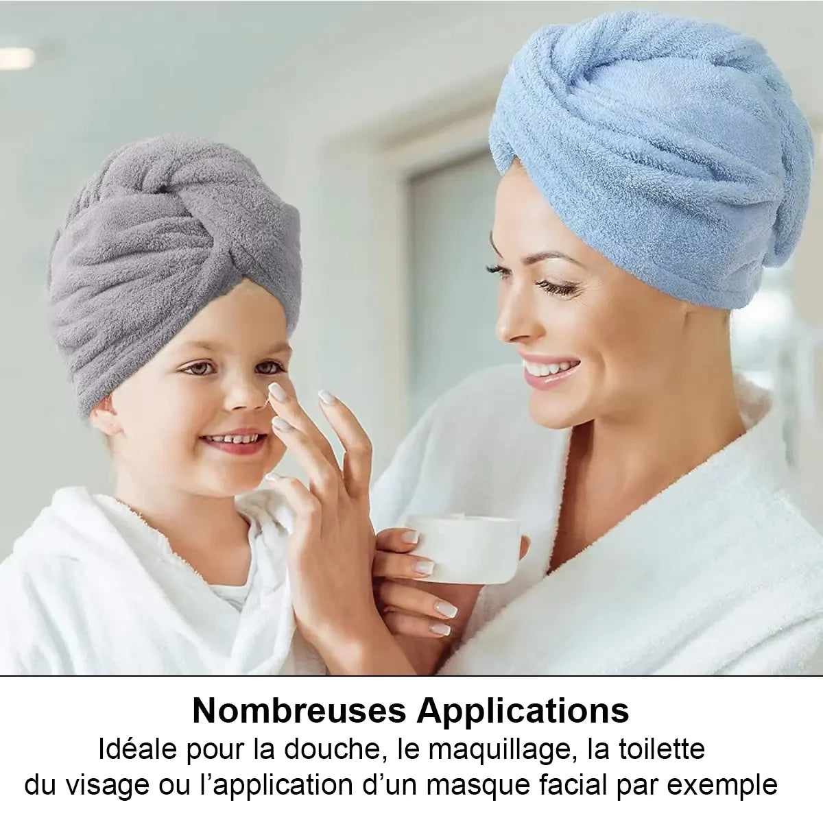 Serviette de séchage des cheveux. Une mère et sa fille avec chacune une serviette sur la tête et la mère applique de la crème a la fille