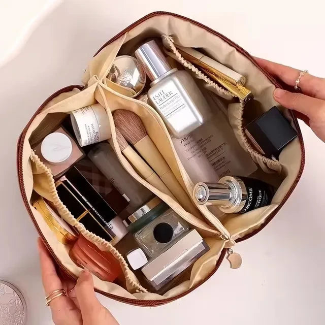 Trousse cosmétique portable de voyage. Elle est présenter ouverte et bien remplie de produits cosmétiques en tous genres