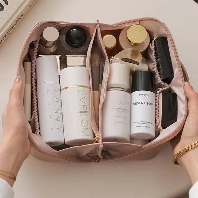 Trousse cosmétique Rose. Présenter grande ouverte par une femme, elle est pleine de produit cosmétiques de tous genres et de parfums, déodorants, etc