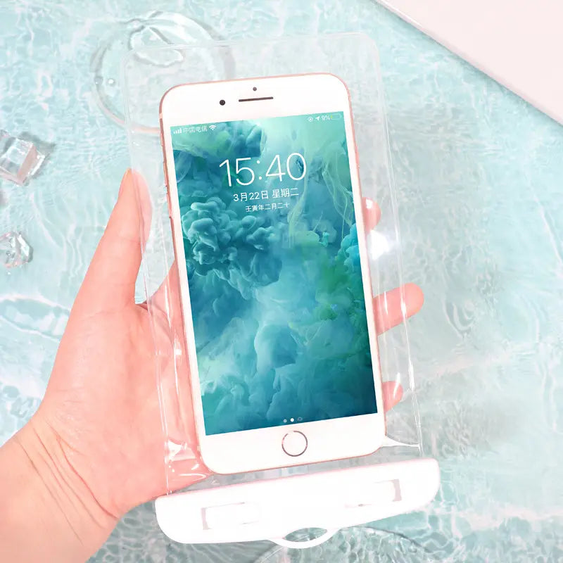 Pochette étanche blanche pour smartphone. Transparente. Présentée devant une piscine, prise en main, avec un iphone blanc a l'intérieur