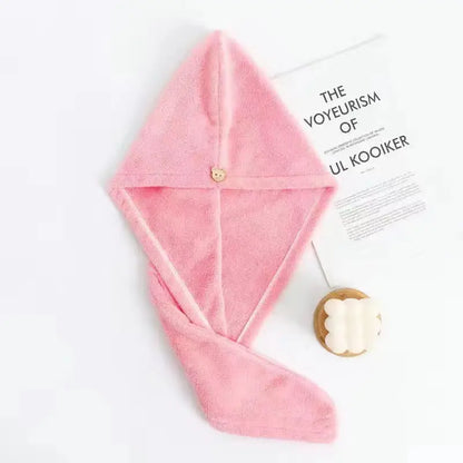 Serviette de séchage des cheveux. Une serviette rose étalée on voit bien la forme de la capuche et le bouton