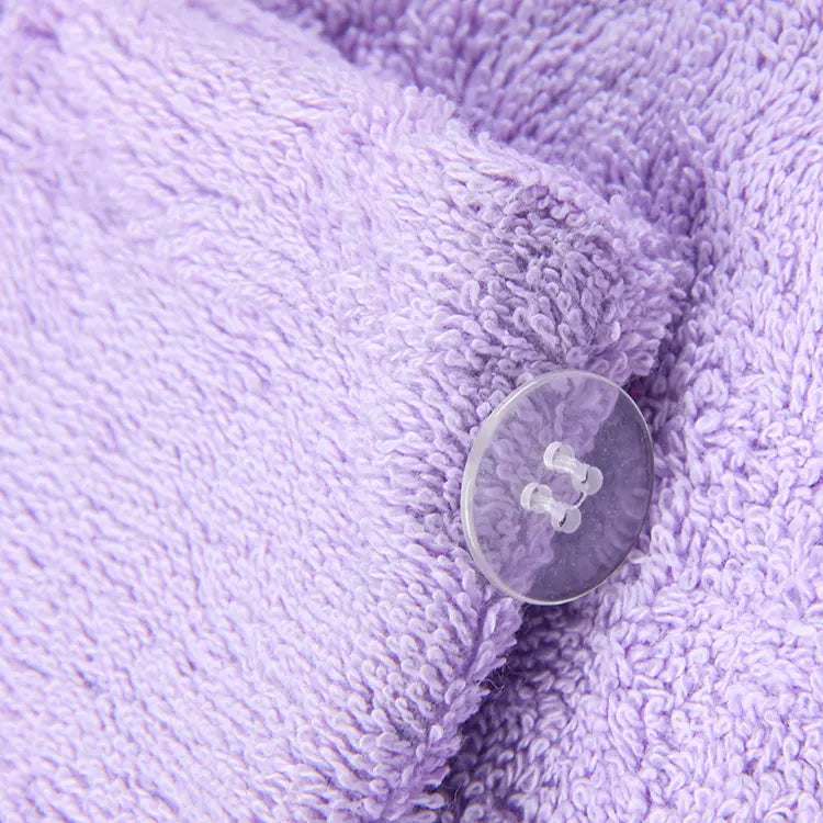 Serviette de séchage des cheveux. Zoom sur le bouton d'une serviette mauve