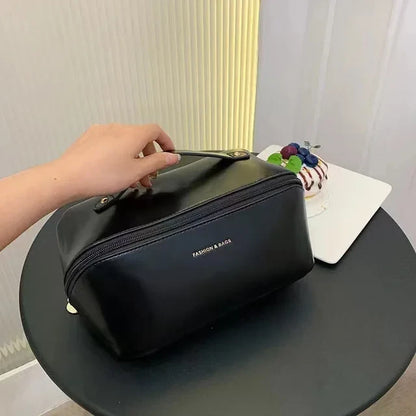 Trousse cosmétique de voyage noire. Femme qui la pose fermer sur une petite table