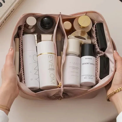 Trousse cosmétique Rose. Présenter grande ouverte par une femme, elle est pleine de produit cosmétiques de tous genres et de parfums, déodorants, etc